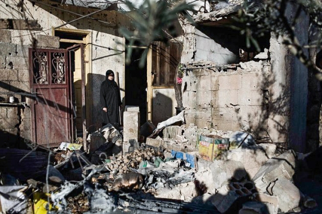 Une femme se tient das les débris de sa maison qui a été détruite par l'Armée syrienne à Al-Qsair. Auteur: freedonhouse (CC BY 2.0)